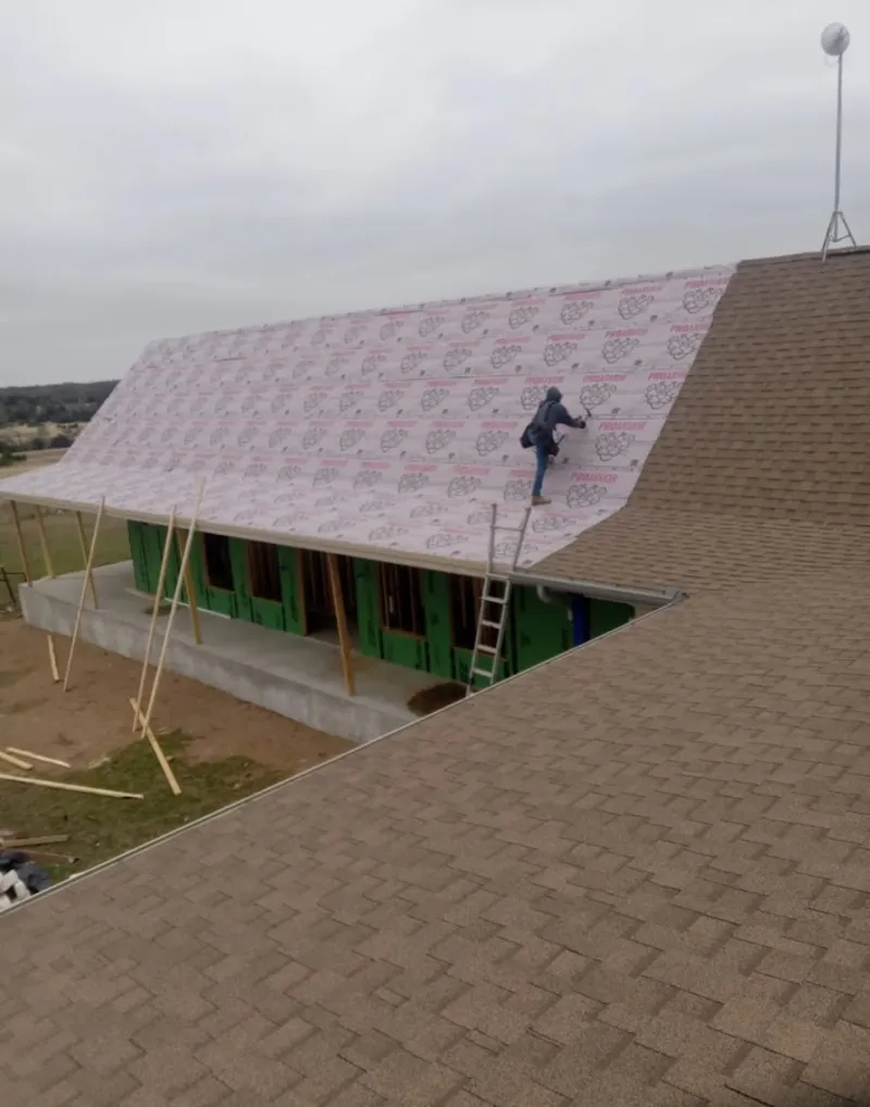 Worker preparing underlayment for a metal roof installation in Scottsbluff
